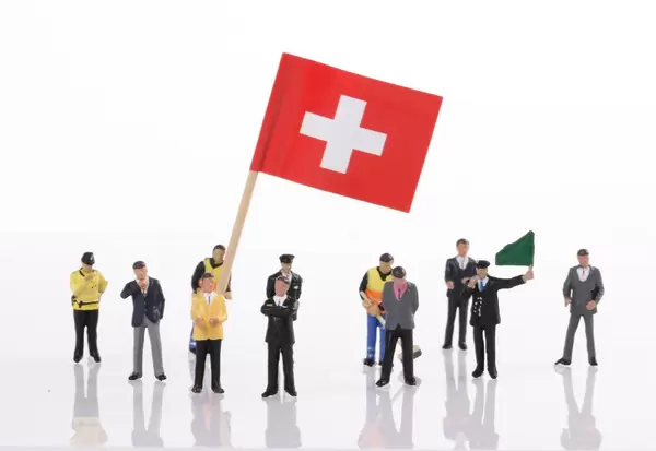 Miniature people with flag of Switzerland