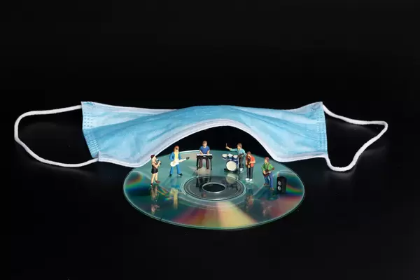 Miniature rock band and medical face mask on black background