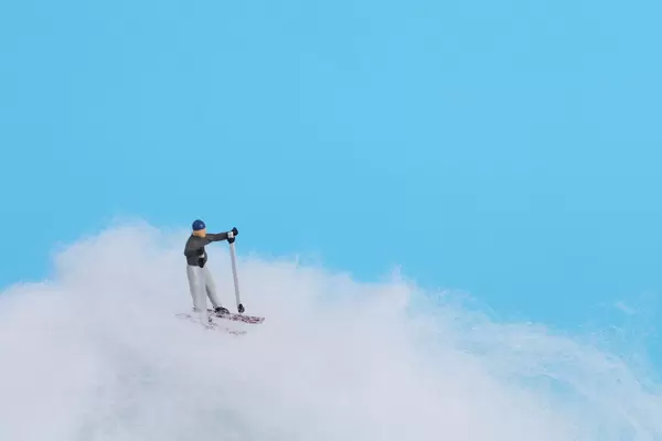 Miniature skier with blue background