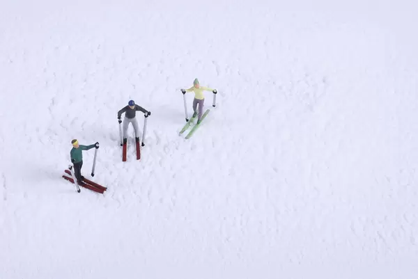 Miniature skiers on snow