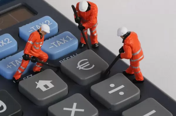 Miniature technician repairing Euro button on calculator