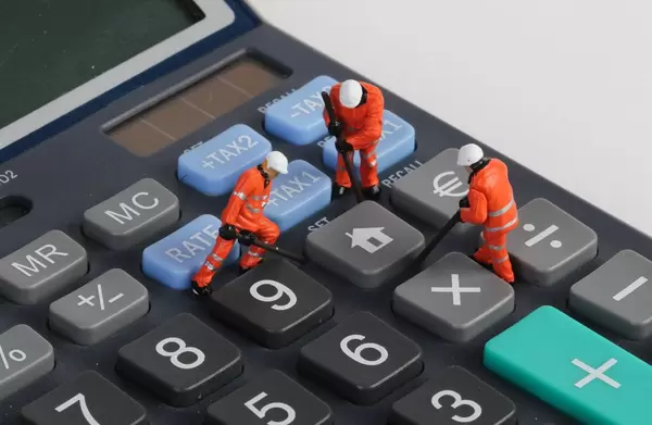 Miniature technician repairing home button on calculator
