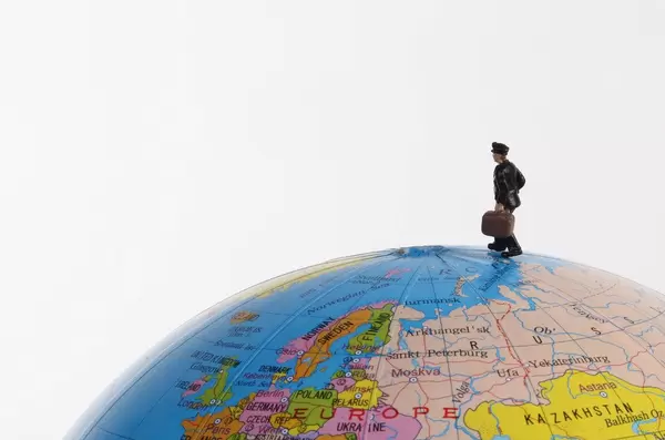 Miniature traveler man on the globe