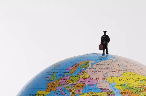 Miniature traveler man on the terrestrial globe