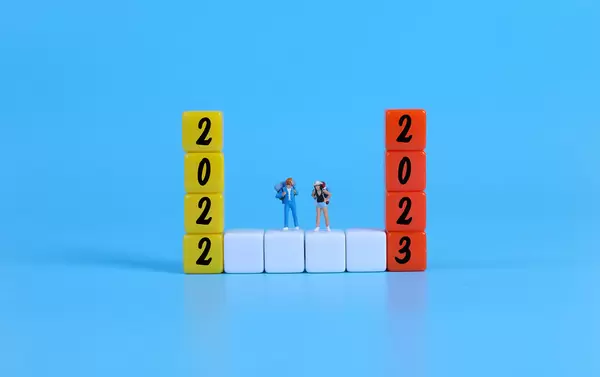 Miniature travelers on blocks with 2022 and 2023 text