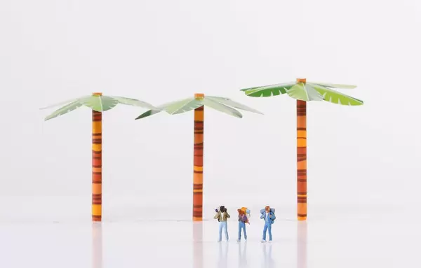 Miniature travelers with trees on white background