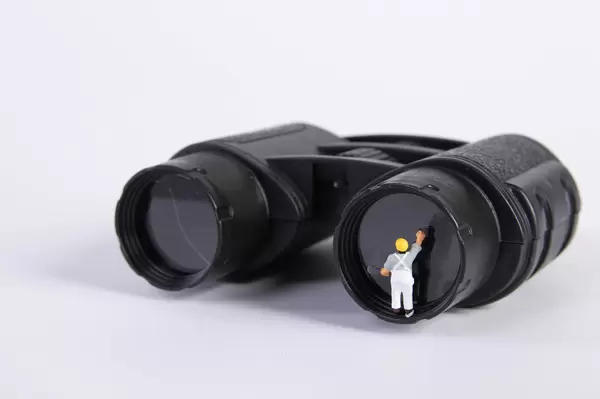 Miniature worker cleaning binocoulars lens