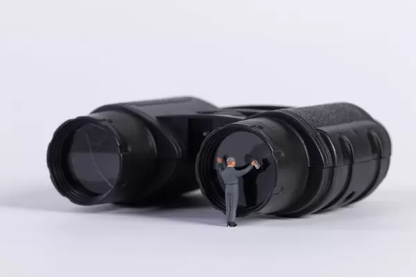 Miniature worker cleaning binocoulars