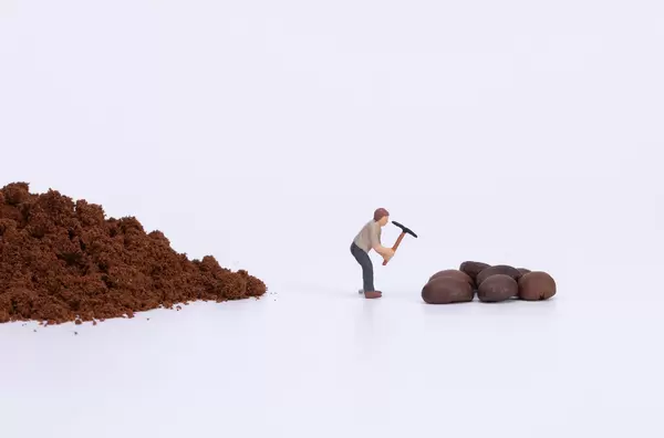 Miniature worker grinding coffee beans