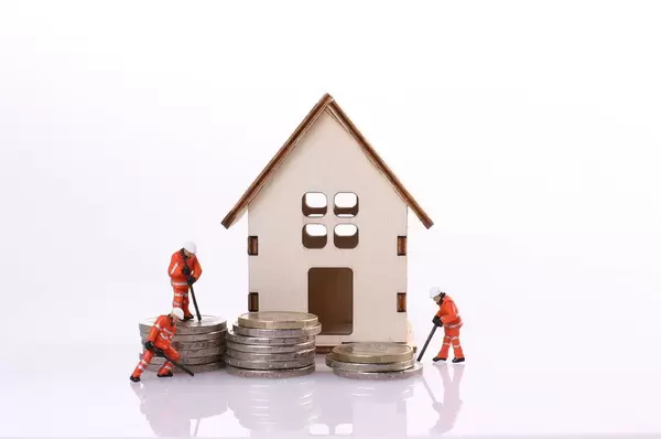 Miniature workers team building a house