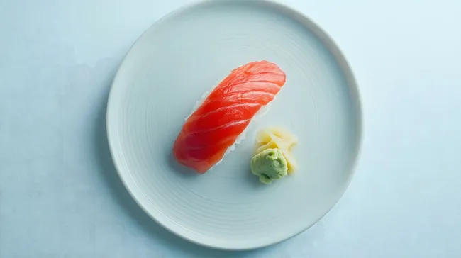 Minimalistisch präsentiertes Sushi mit frischem Lachs und Wasabi