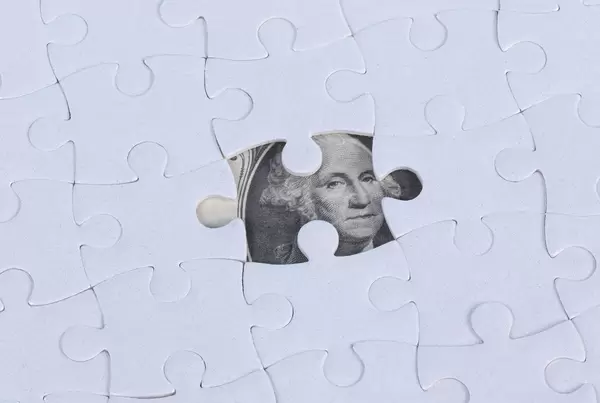 Missing jigsaw puzzle piece on 100 Dollar money background