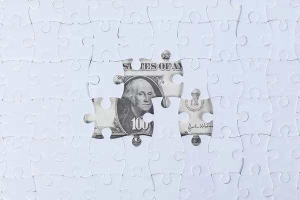 Missing jigsaw puzzle pieces on money dollar background