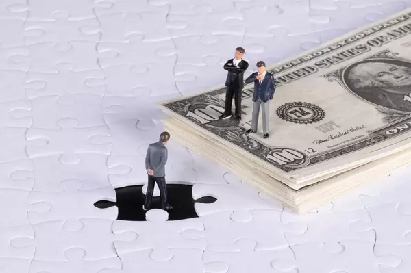Missing puzzle piece with group od businessman and stack of 100 Dollar banknotes