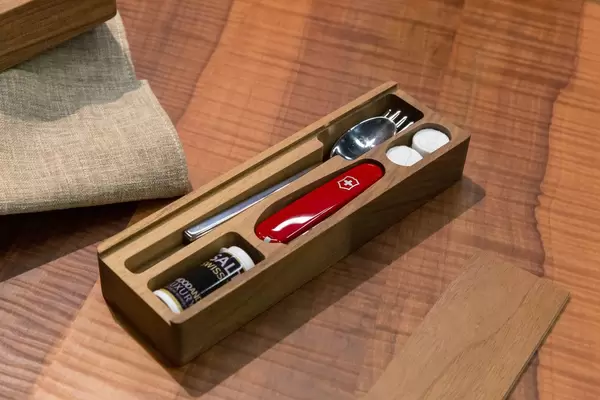 Mit Deckel verschließbare Holzkiste mir Besteck, Schweizer Taschenmesser und Gewürzen