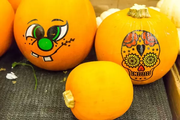 Mit Halloween-Motiven bemalte Kürbisse im Supermarkt