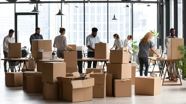 Mitarbeiter beim Umzug in modernes Großraumbüro