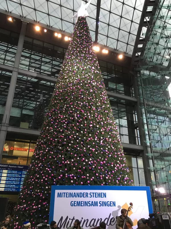 Miteinander stehen, gemeinsam singen im Berliner Hauptbahnhof vor Weihnachtsbaum