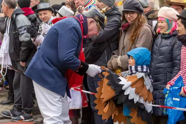 Mitglied der Kölsche Funkentöter von 1932 gibt einem Jungen ein Geschenk - Kölner Karneval 2018