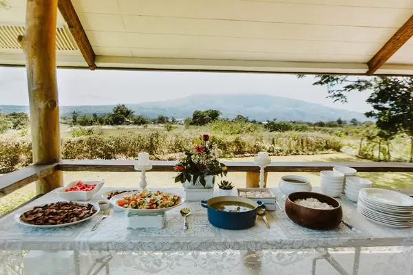 Mittagsbuffet mit Gemüse, Reis und Fleisch vor wunderschöner Aussicht in die Natur
