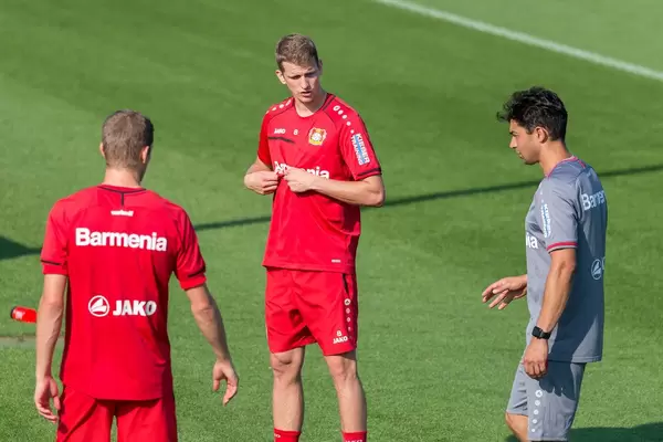 Mittelfeldspieler Lars Bender redet beim Training mit seinen Teamkollegen auf dem Fußballfeld