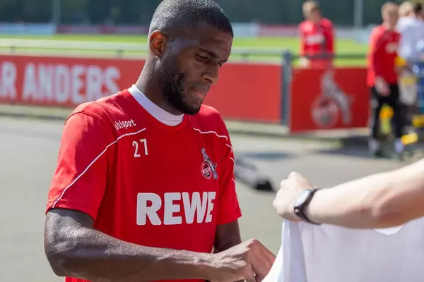 Mittelstürmer Anthony Modeste unterschreibt nach dem Fußballtraining am Geißbockheim mit seinem Autogramm auf Fanartikel