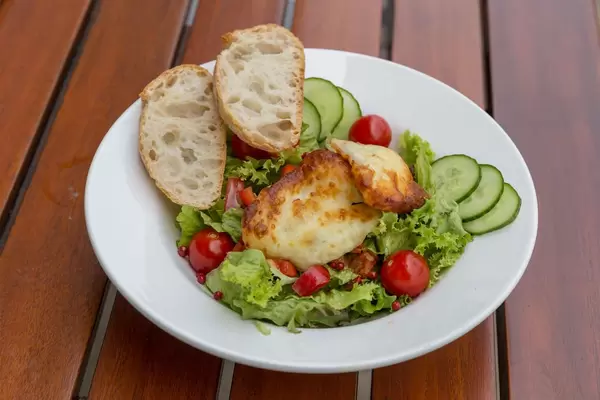 Mixed salad with cucumber, cherry tomato, halloumi cheese and two slices of bread