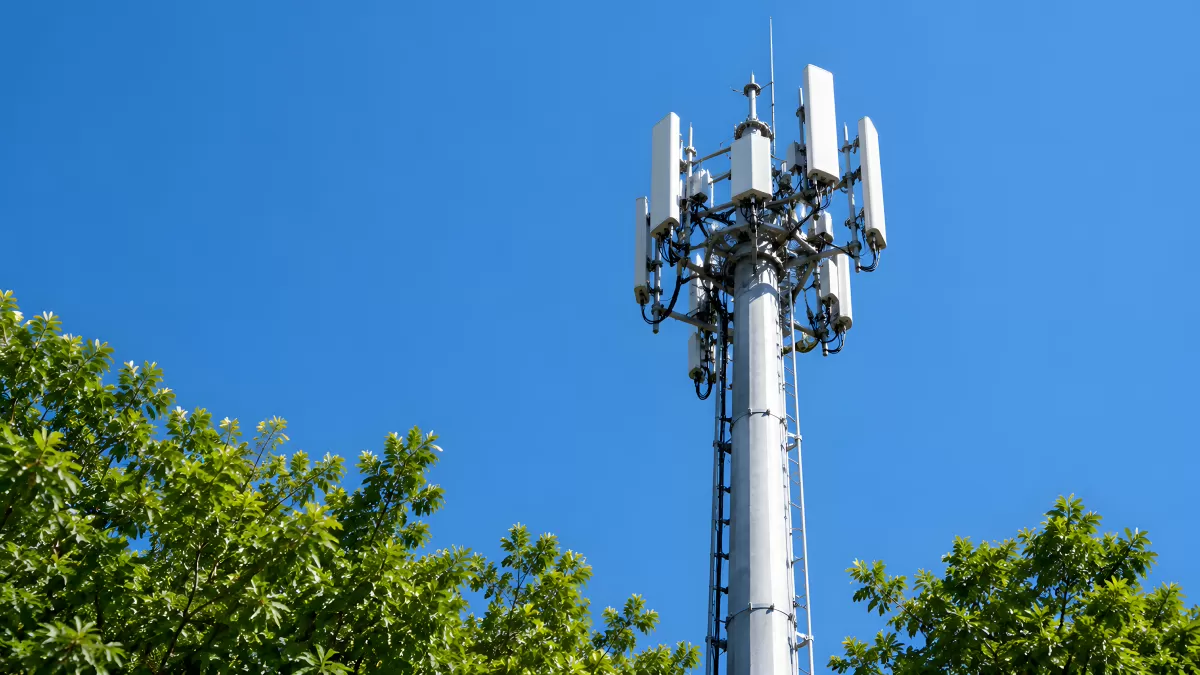Mobilfunkmast mit Antennen vor blauem Himmel