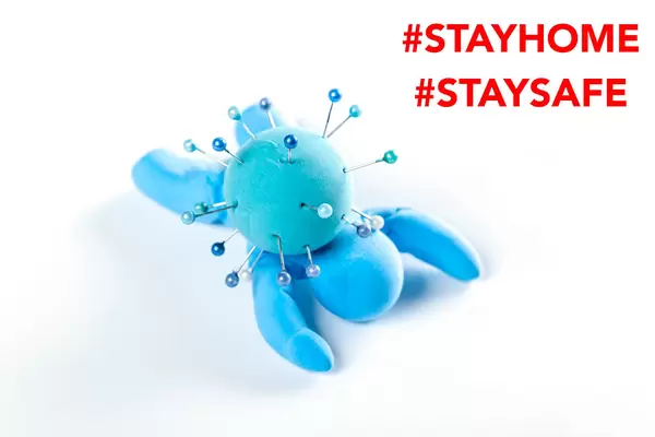 Model lies a person and a virus on it, the concept of stay at home