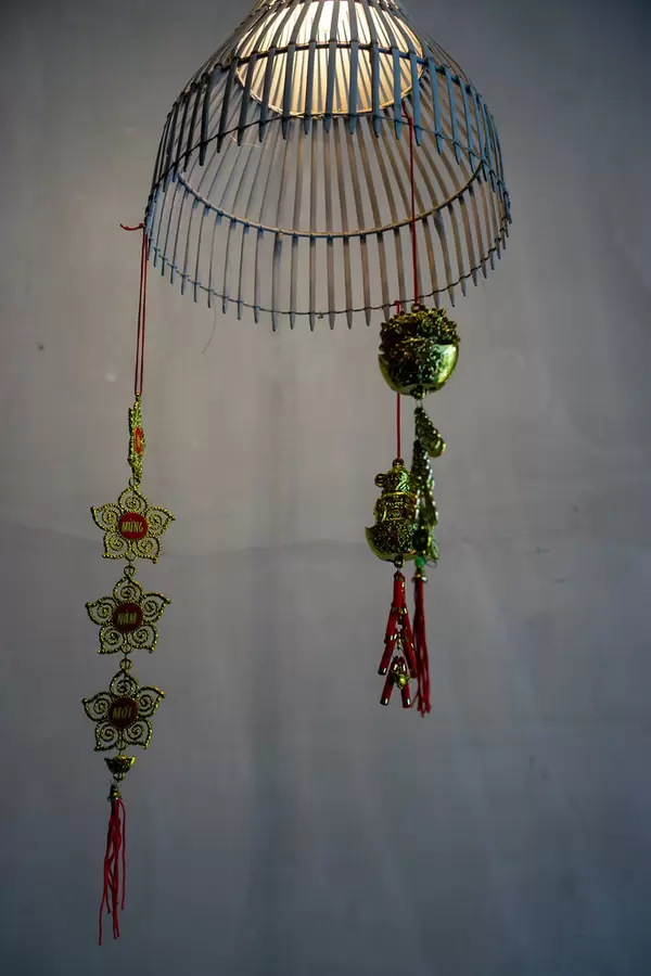 Modern Ceiling Lamp with Bright Light Bulb with Hanging Red Ornaments as Decoration in a Restaurant