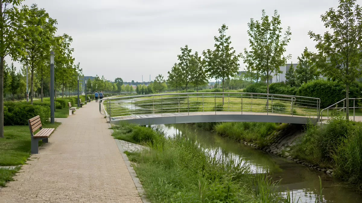 Moderne Fußgängerbrücke über Bach im Stadtpark