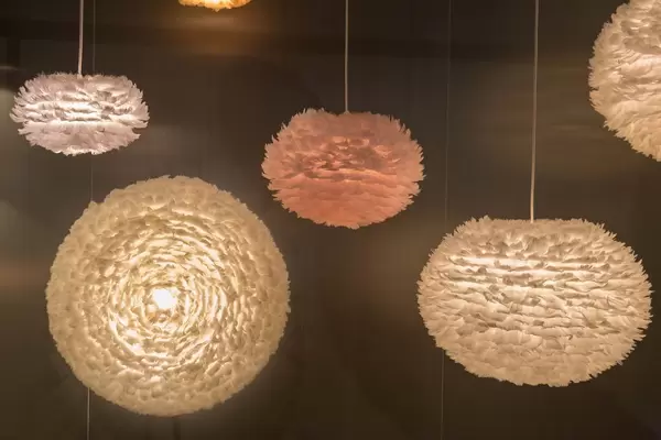 Moderne, kugelförmige Lampen aus Federn für weiches, gedämmtes Licht vor dunklem Hintergrund