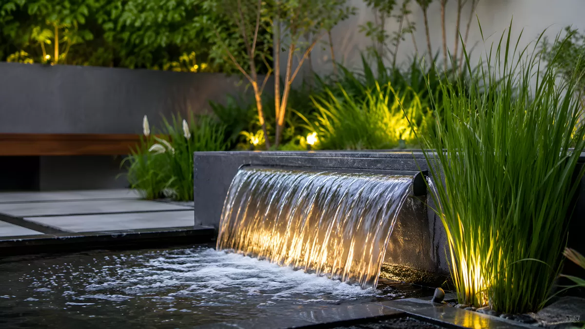 Moderner Gartenbrunnen mit Wasserkaskade bei Nacht
