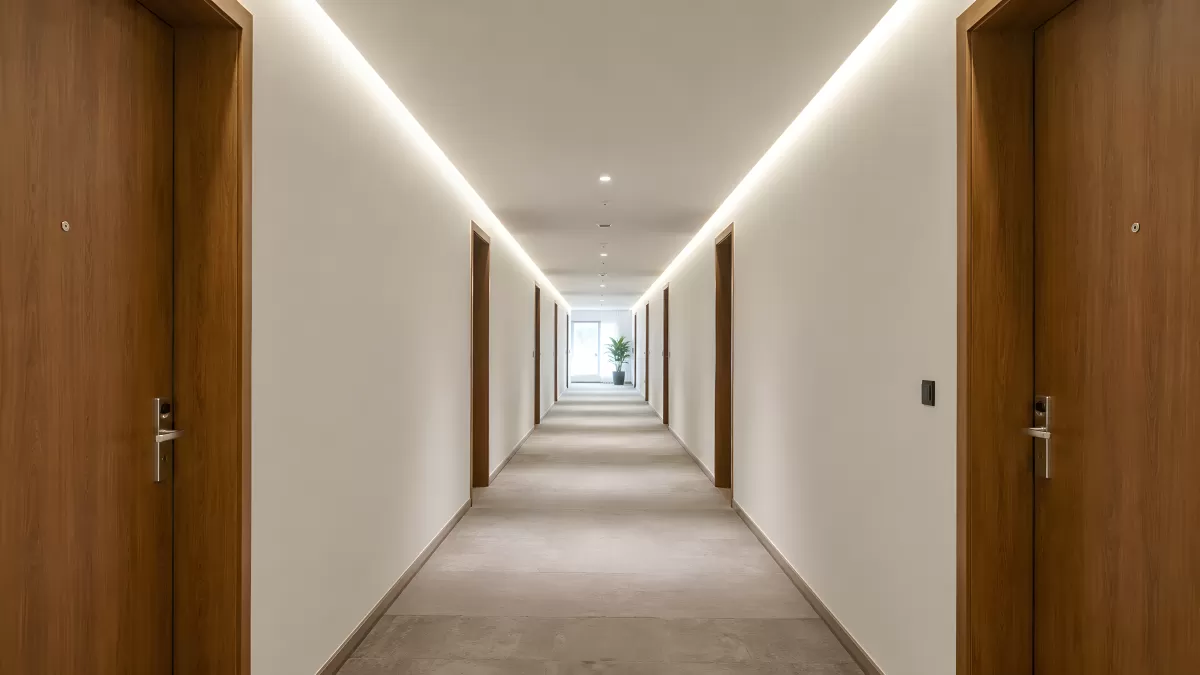 Moderner Hotelflur mit Holztüren und indirekter Beleuchtung
