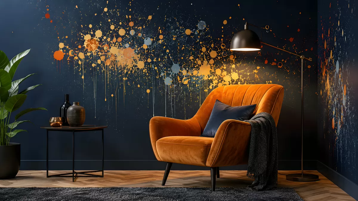 Moderner Sessel in Orange vor dunkelblauer Farbspritzer-Wand