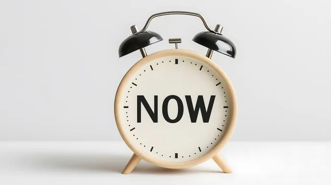 Moderner Wecker mit Aufschrift 'Now' - Zeitmanagement-Konzept