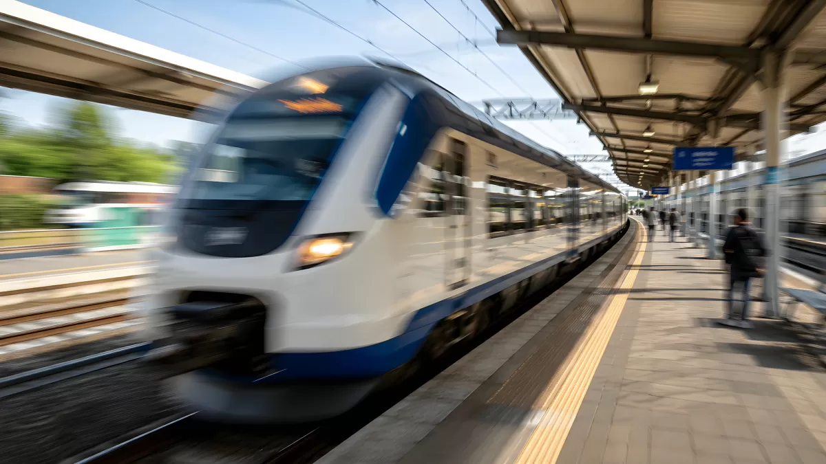 Moderner Zug fährt mit hoher Geschwindigkeit in Bahnhof ein
