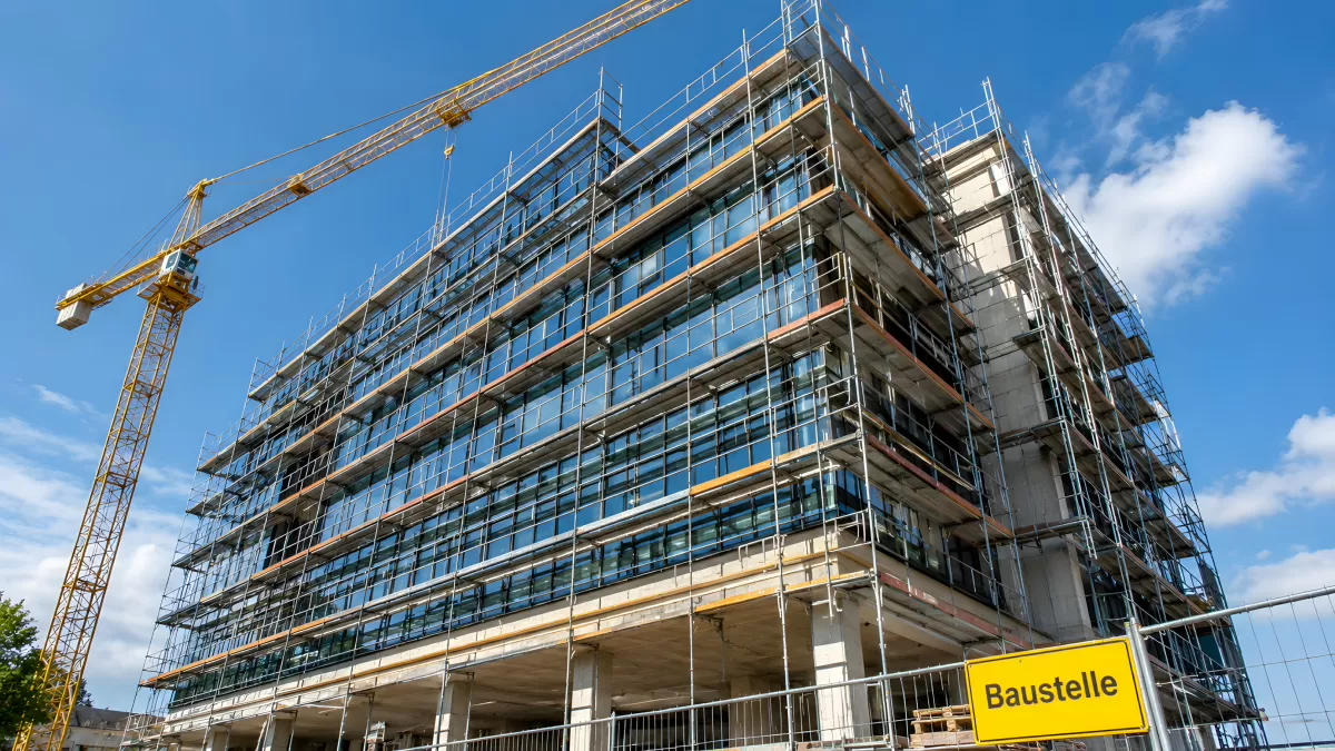 Modernes Bürogebäude im Bau mit Gerüst und Kran