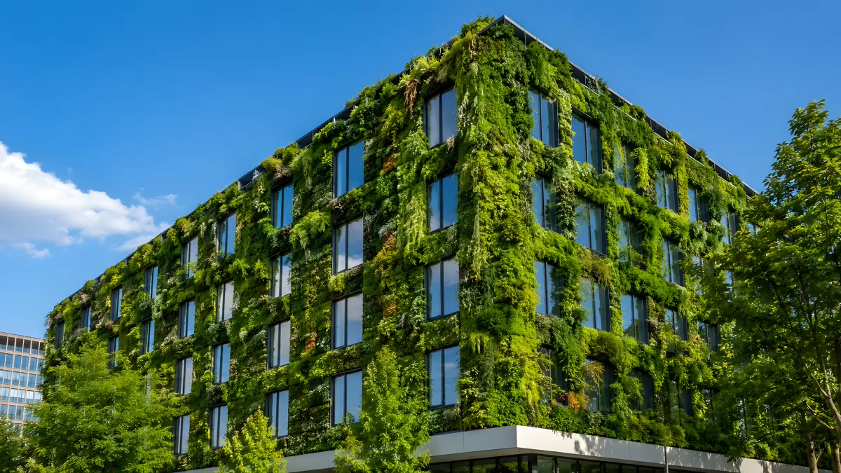 Modernes Bürogebäude mit üppiger grüner Fassadenbegrünung