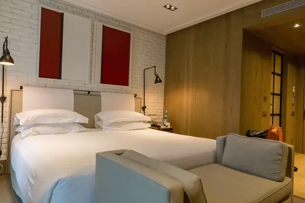 Modernes Doppelbett-Hotelzimmer des "The Corner Hotel" in Barcelona, Spanien, weißen Mauersteinen an der Carrer de Mallorca & Carrer de Muntana
