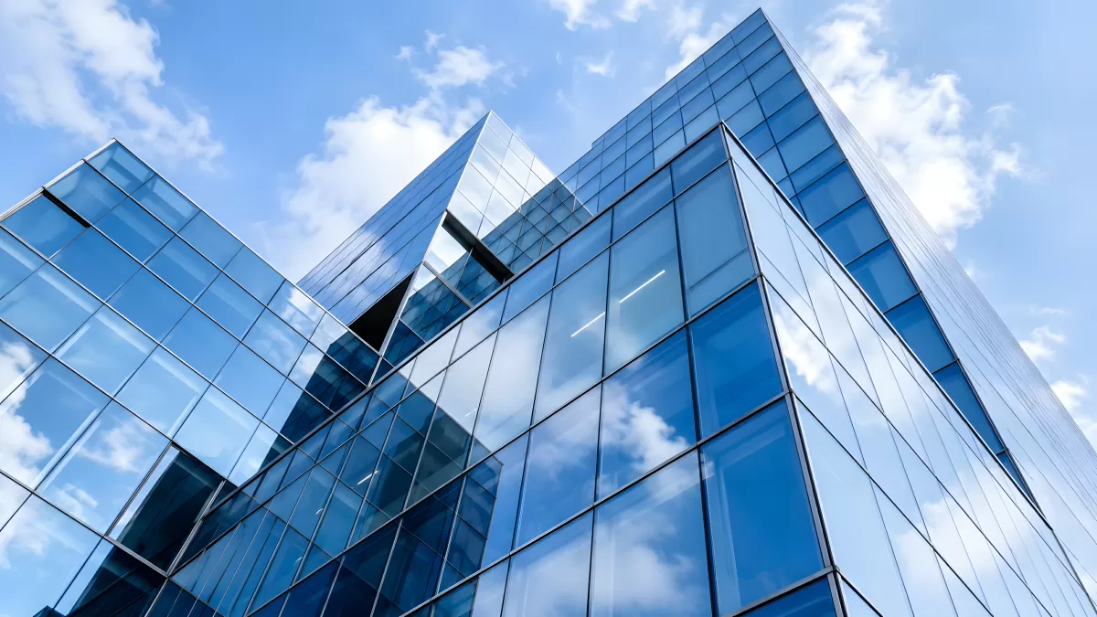 Modernes Glasgebäude von unten mit blauem Himmel