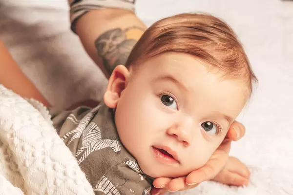 Mom's hand hugs her son's face