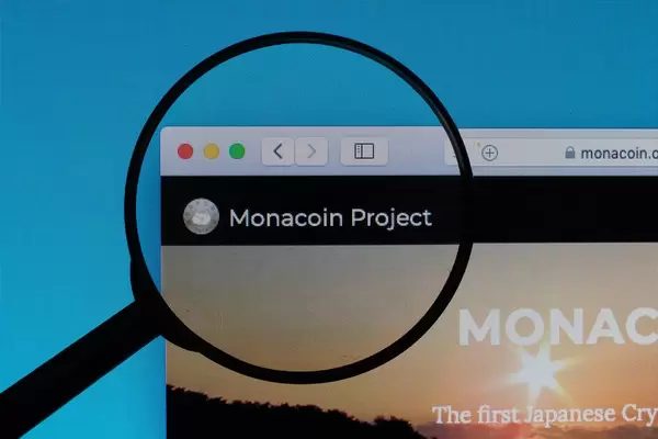 Monacoin Project logo under magnifying glass