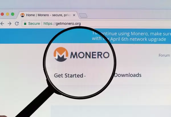 Monero logo on a computer screen with a magnifying glass