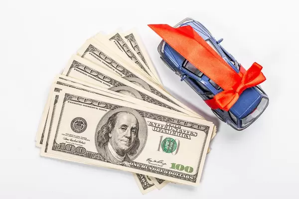 Money and metal car model with red gift ribbon on white background (Flip 2019)