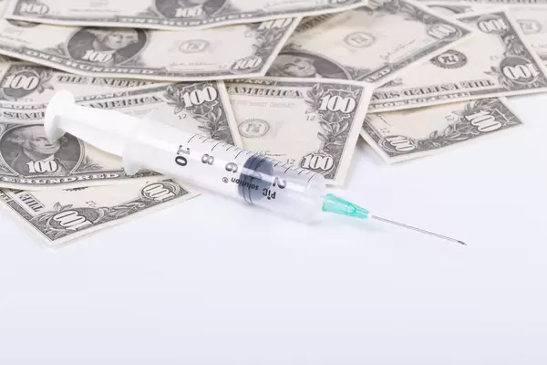 Money and syringe on white background