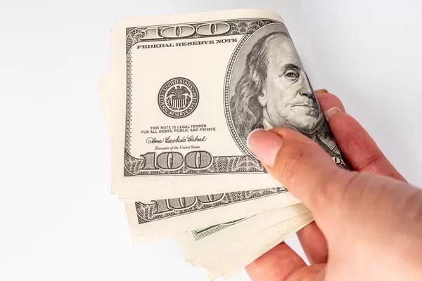Money in the hands of a woman on a white background