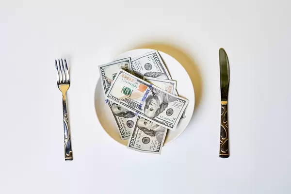 Money on the plate with fork and knife - greedy corruption or bribe idea