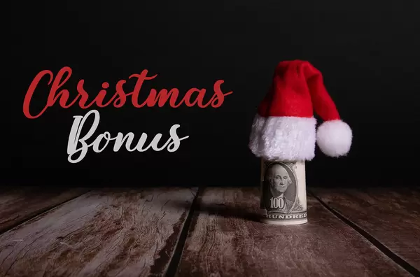 Money roll with Christmas hat and Christmas Bonus text on black background