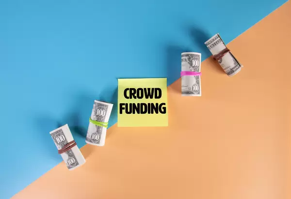 Money rolls and sticky note with Crowd Funding text